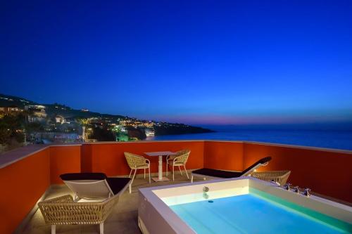 a hot tub on a balcony with chairs and a table at Hotel Lorelei Londres in Sorrento