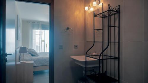グラナディージャ・デ・アボナにあるOkeanos Super 2 bedrooms LT-Pのバスルーム(シンク、ベッド、鏡付)