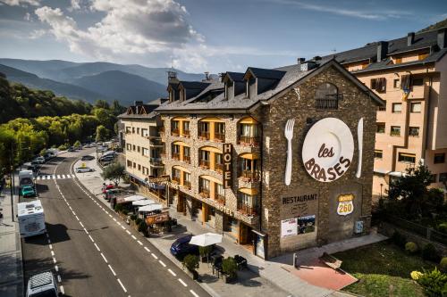 a building with a sign on the side of a street at Hotel Restaurant Les Brases in Sort