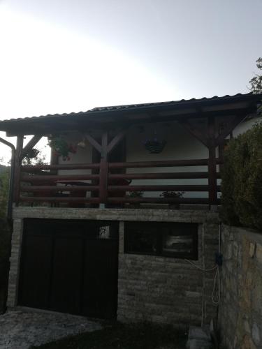 a wooden pergola on a house with a garage at Tri bagrema KM in Mokra Gora