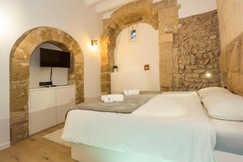 um quarto com uma cama e uma parede de pedra em studio cave em Palma de Maiorca