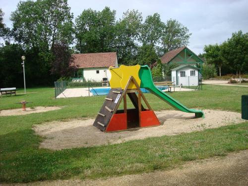 a playground with a slide in a park at Village-Chalets Le Rû du Pré in Cravant