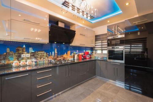 a kitchen with gray cabinets and a city skyline on the wall at Villa Shameti - Private Villa with Pool and Billiards Near Zakynthos Town By Villa Mana Gers in Zakynthos Town