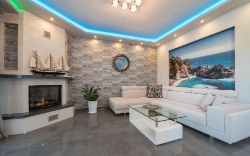 a living room with a white couch and a fireplace at Villa Shameti - Private Villa with Pool and Billiards Near Zakynthos Town By Villa Mana Gers in Zakynthos Town