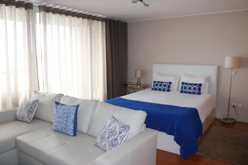 a large white bed with pillows in a room at Bartolomeu Beach Apartments in Porto