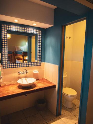 un bagno con lavandino, WC e specchio di America Del Sur Calafate Hostel a El Calafate