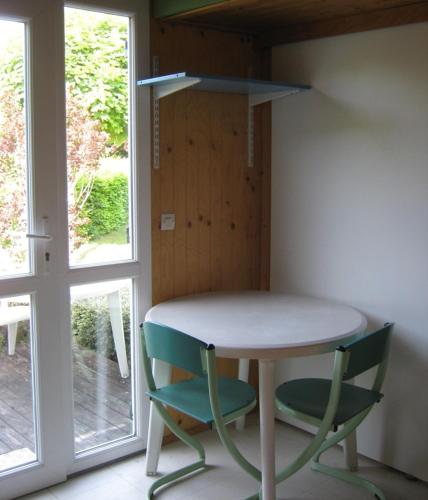 a table and two chairs in a room with a window at Village-Chalets Le Rû du Pré in Cravant