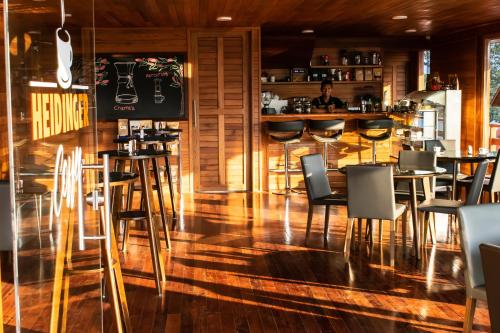 un restaurante con suelo y sillas de madera y un bar en Hotel Heidinger, en Oxapampa