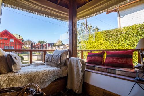 a window seat with pillows on a porch at B&B HMüller in Pucón
