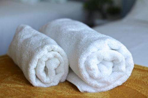 two rolls of white towels sitting on a table at 2 Bedrooms - 3 Beds - Free Parking - 168 in Stanwell