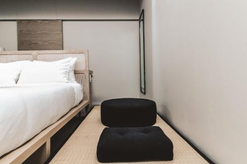 a bedroom with a black chair next to a bed at RYO KAN Ciudad de México in Mexico City
