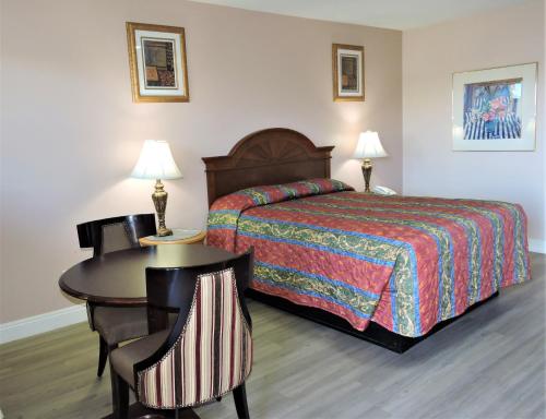 a hotel room with a bed and a table and chairs at American Inn in Las Vegas