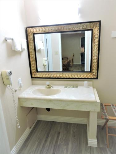 a bathroom with a sink and a mirror at American Inn in Las Vegas