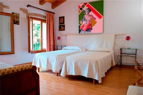 a bedroom with two beds and a painting on the wall at B&B in Valle in Lumignano