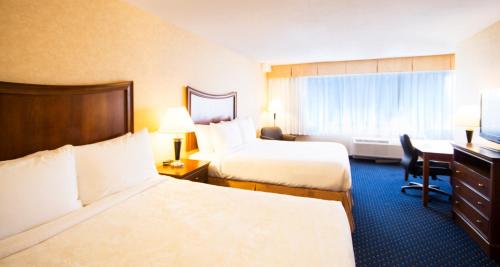 a hotel room with two beds and a desk at Best Western Plus Suites Downtown Calgary in Calgary