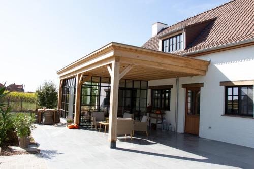 a wooden pergola on a patio of a house at Madelette B&B in Moorslede