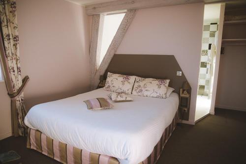 サン・フルールにあるLa Maison d'Adelaïdeのベッドルーム1室(大型ベッド1台、白いシーツ、枕付)