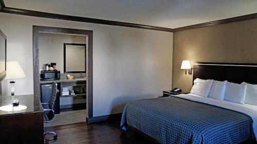 ein Hotelzimmer mit einem Bett und einem Spiegel in der Unterkunft Hawthorne Plaza Inn Near LAX in Hawthorne