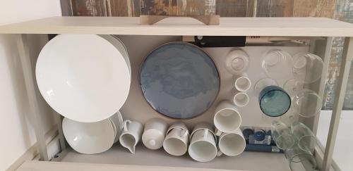 a shelf filled with cups and other ceramics at Mini-villa 1 MER in Porto-Vecchio