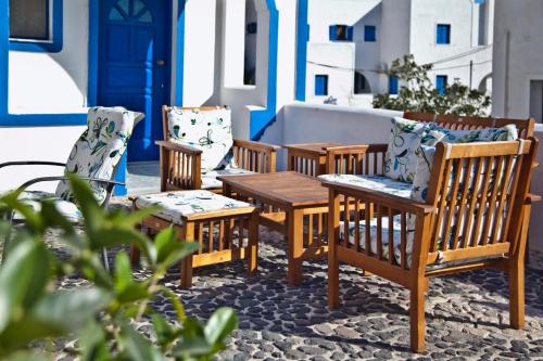 a group of chairs and a table on a patio at Roula Villa Studios & Apartments in Perissa