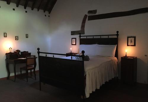 a bedroom with a bed and a desk with two candles at Casina Della Burraia in Subbiano