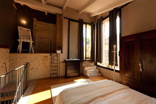 a bedroom with a bed in a room with windows at Antico Hospitale in Dogliani