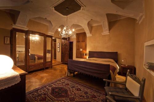 a large bedroom with a bed and a chandelier at Antico Hospitale in Dogliani