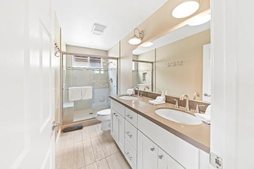 a bathroom with two sinks and a toilet and a mirror at 253 Four Bedroom in Huntington Beach