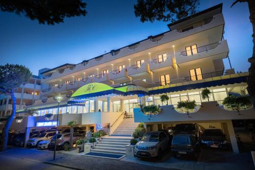 un hôtel avec des voitures garées devant lui dans l'établissement Hotel Coralba, à Caorle