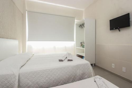 Un dormitorio con una cama y un televisor de pantalla plana. en Ilha Norte Apart Hotel, en Florianópolis