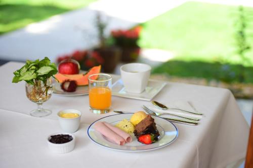 a table with two plates of food and orange juice at Quintas do Arraial Guest House in Arraial d'Ajuda