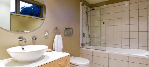 a bathroom with a sink and a toilet and a tub at Penthouse 39 in Nelson