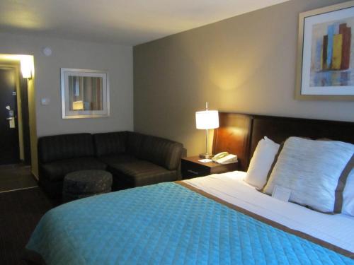 a hotel room with a bed and a couch at Wyndham Garden Midland in Midland