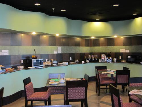 a restaurant with tables and chairs and a counter at Wyndham Garden Midland in Midland