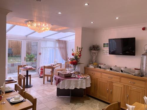 a living room with a table and a tv at Jessamine House Hotel in Gravesend