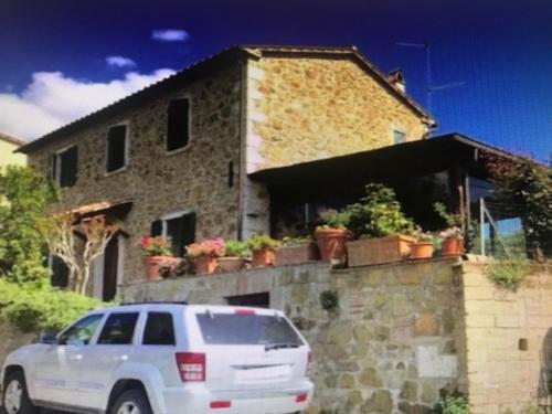 a white van parked in front of a stone house at CASA LORY Poggio Murella in Poggio Murella