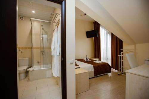 a bathroom with a bed and a bathroom with a shower at Hotel Sofia in Adler