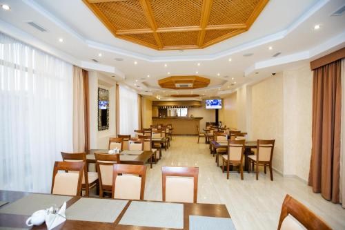 uma sala de jantar com mesas e cadeiras num restaurante em Hotel Sofia em Adler