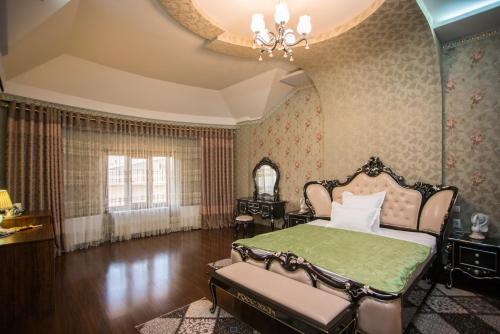 a bedroom with a bed and a chandelier at Caravan Castle Boutique Hotel in Bukhara