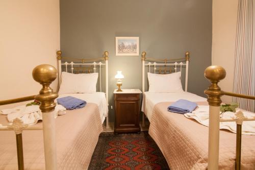 1 dormitorio con 2 camas con sábanas blancas y toallas azules en Villa Magia, en Ýpsos