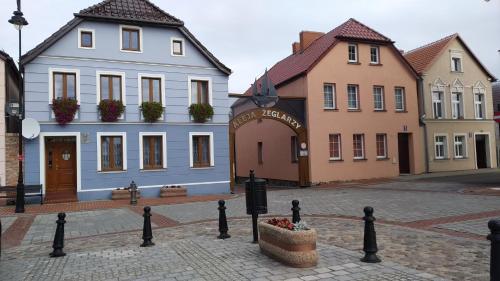 a group of buildings on a street with a basket of flowers at Villa Helena in Nowe Warpno