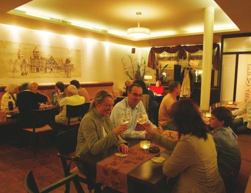 eine Gruppe von Menschen, die an einem Tisch in einem Restaurant sitzen in der Unterkunft Hotel Restaurant Goldener Engel in Heppenheim an der Bergstrasse