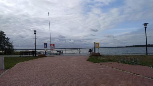 a brick walkway next to a body of water at Villa Helena in Nowe Warpno