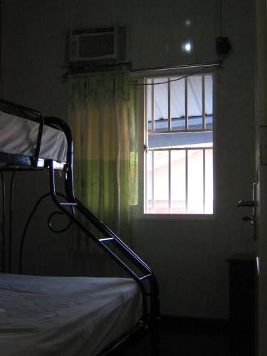 a bedroom with a bed and a window at Cosy home for short stay or a weekend getaway in Paramaribo