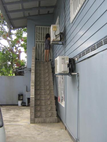 a girl standing on the stairs of a house at Cosy home for short stay or a weekend getaway in Paramaribo