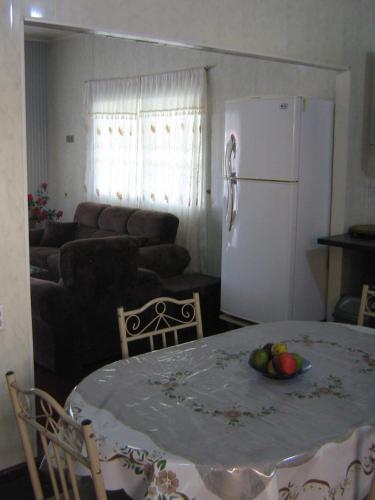 a kitchen with a table and a white refrigerator at Cosy home for short stay or a weekend getaway in Paramaribo