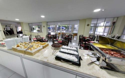 una línea de buffet en un restaurante con comida. en Lagoa Mar Inn - Estacionamento e duas crianças de até 10 anos Será Free, en Maceió