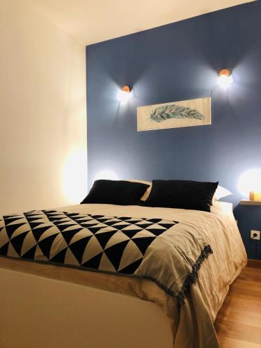 - une chambre dotée d'un lit avec un mur bleu dans l'établissement #T3 intra-muros Avignon, à Avignon