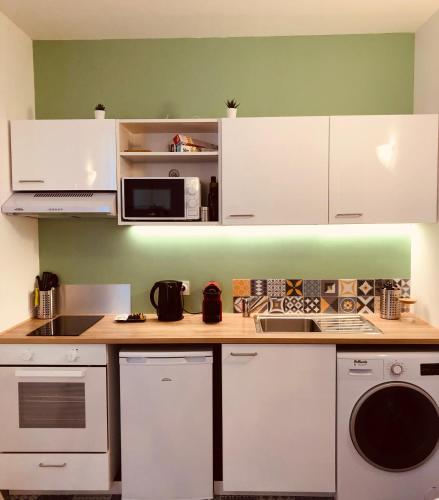 Una cocina con gabinetes blancos y un microondas. en #T3 intra-muros Avignon, en Aviñón