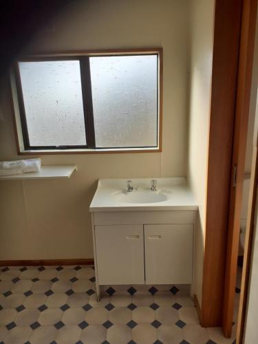 baño con lavabo y ventana en Moeraki Beach Motels en Moeraki